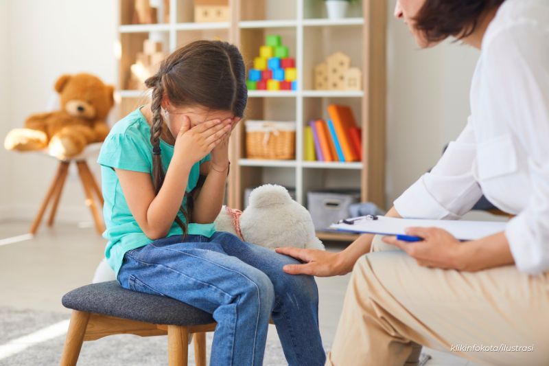 anak kecil menutup wajah, tampak cemas saat diminta duduk diam